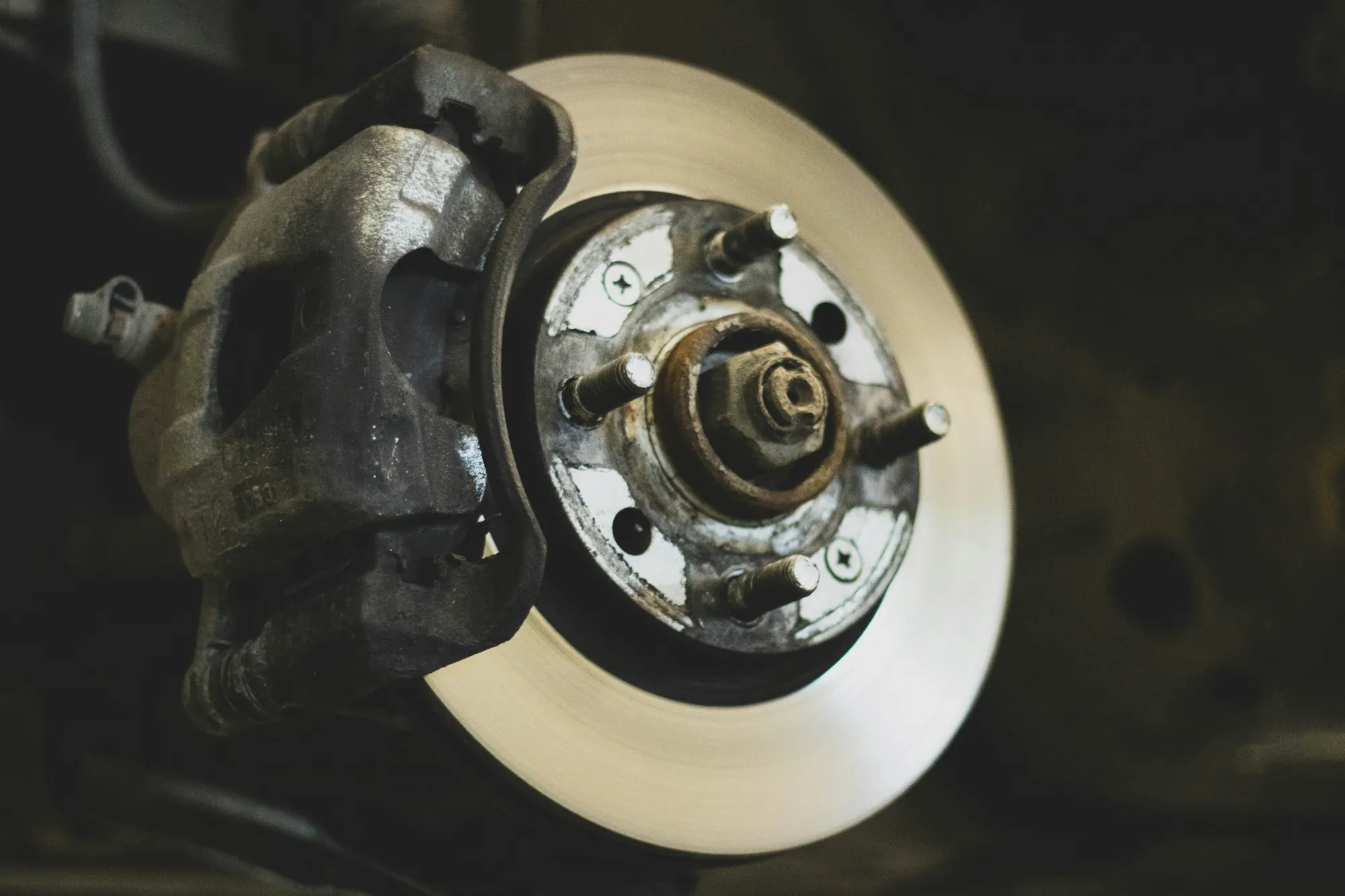 Brake rotor and caliper on a car raised on jack stands