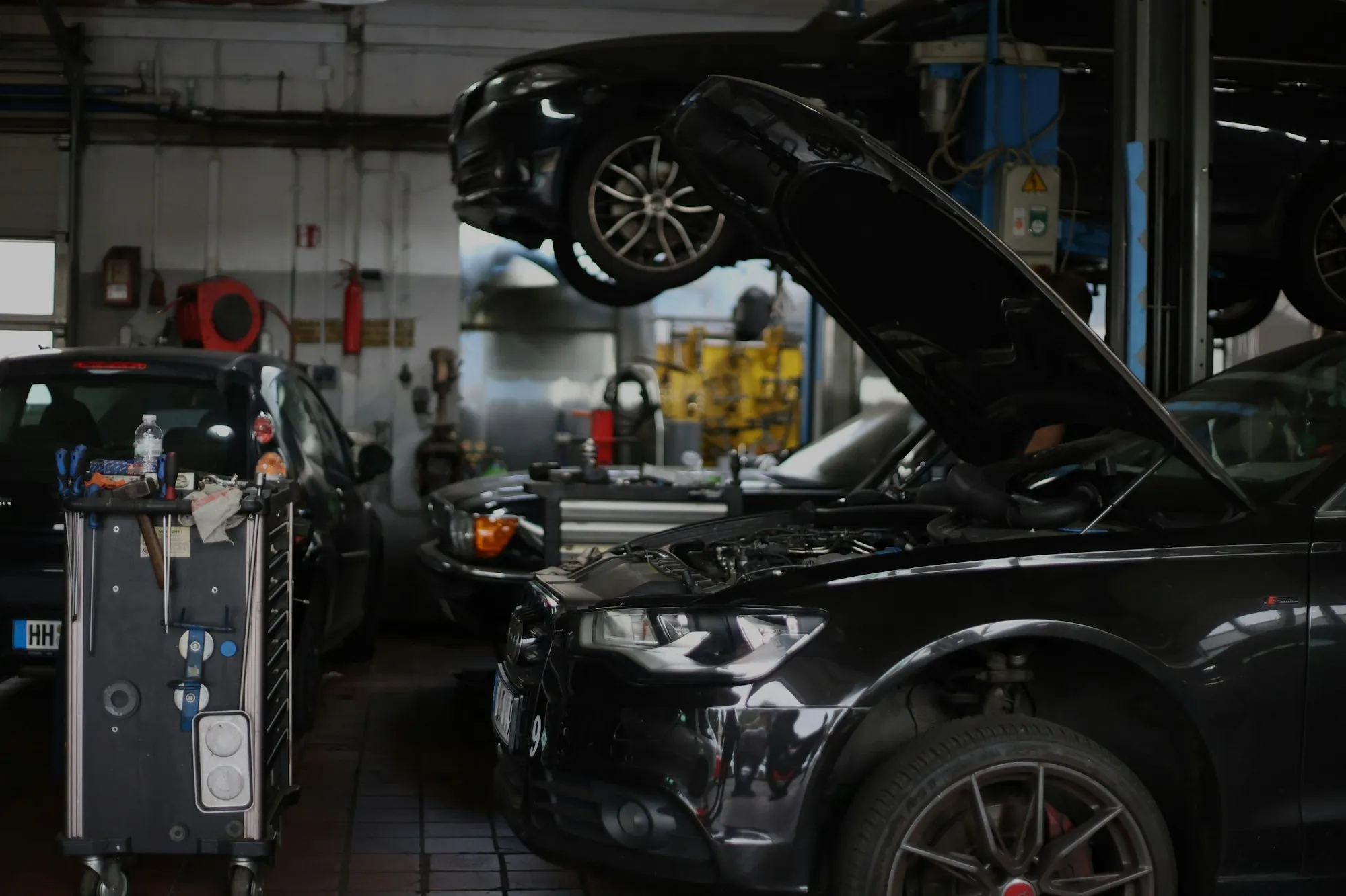 Vehicles raised on lifts inside a repair shop