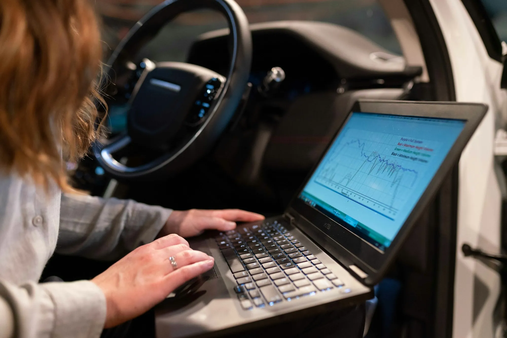 Laptop showing diagnostic data inside a vehicle