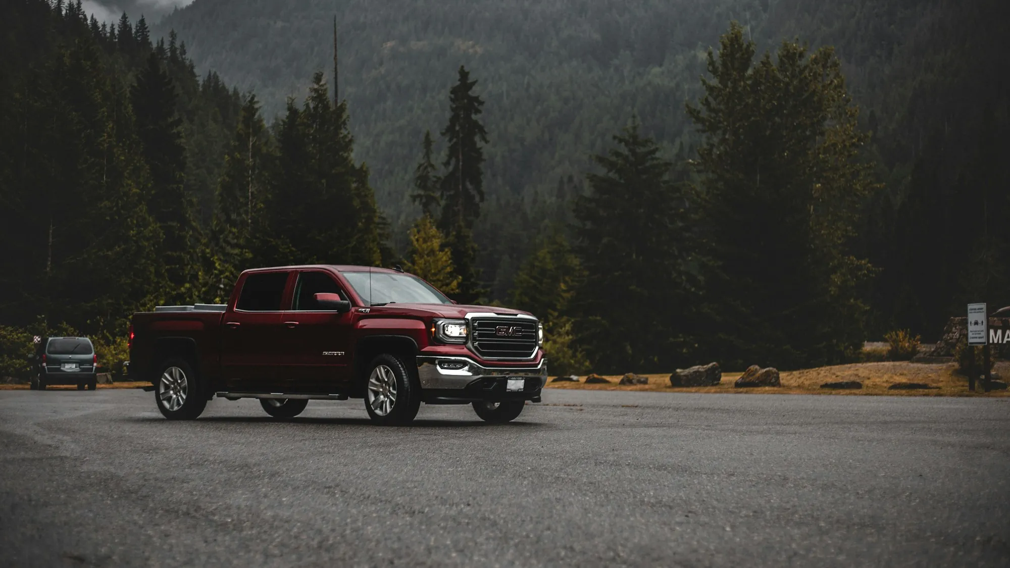 Red pickup truck parked on a forest road