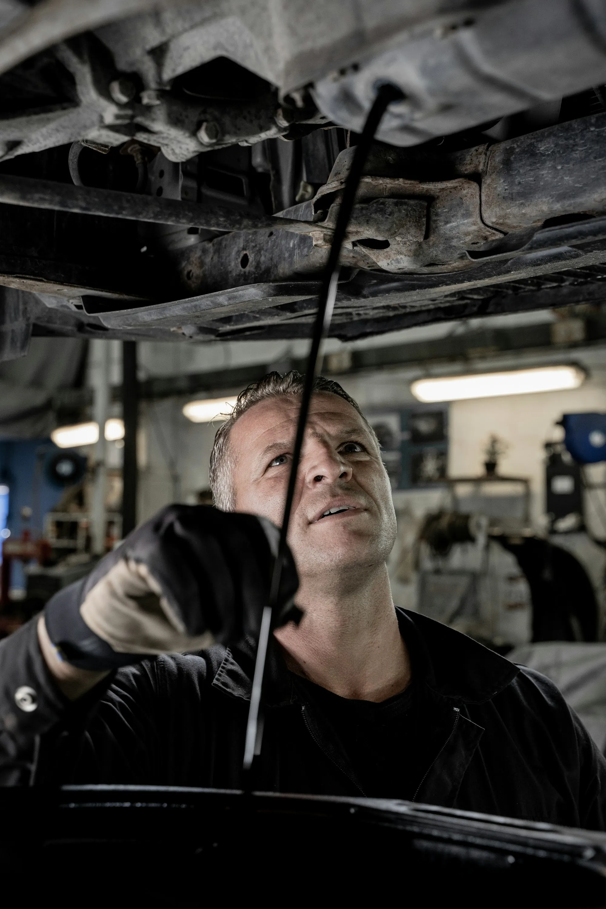 Mechanic working beneath a vehicle raised on a lift